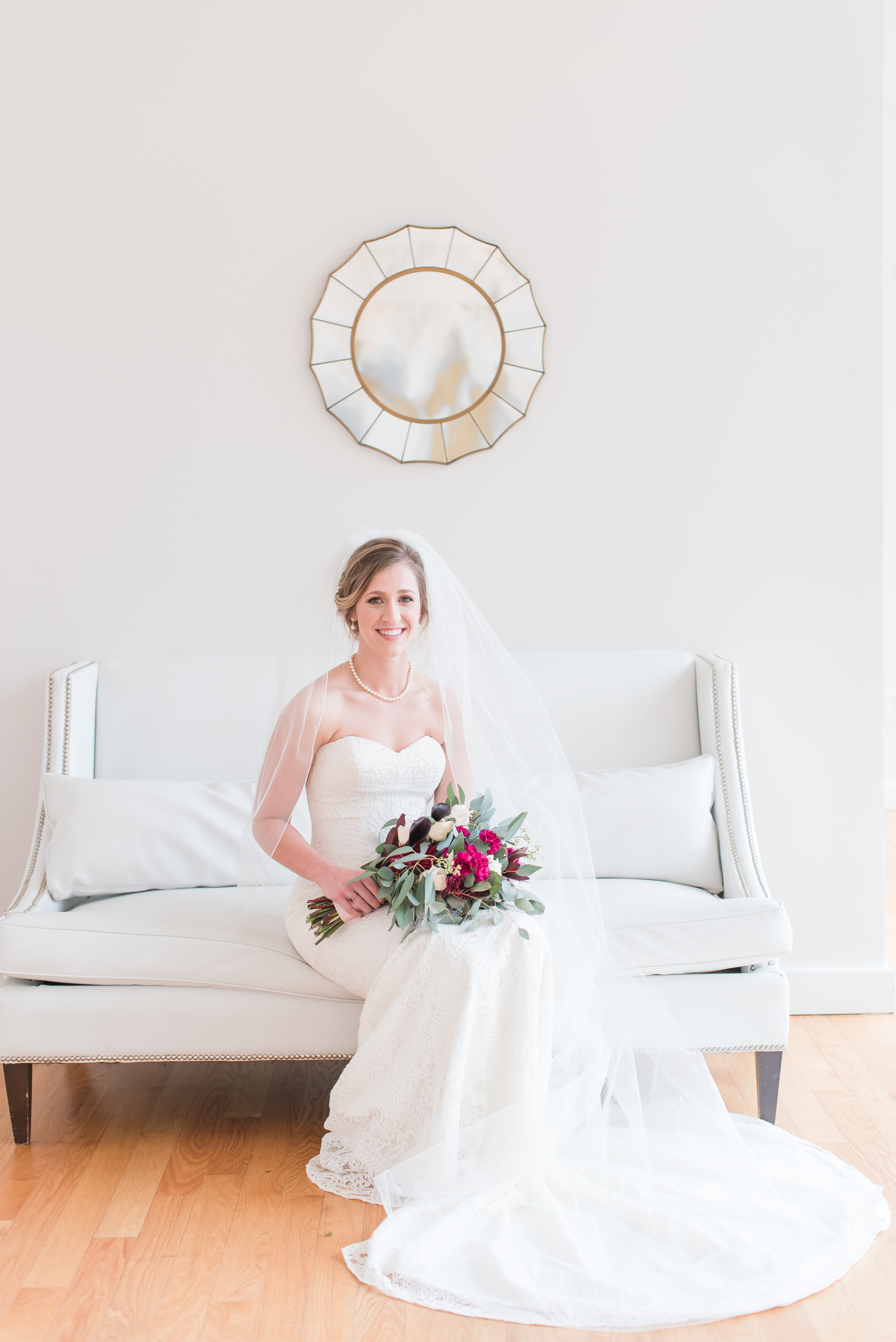 bride sitting on the couch holding the bridal bouquet at the Glass Box