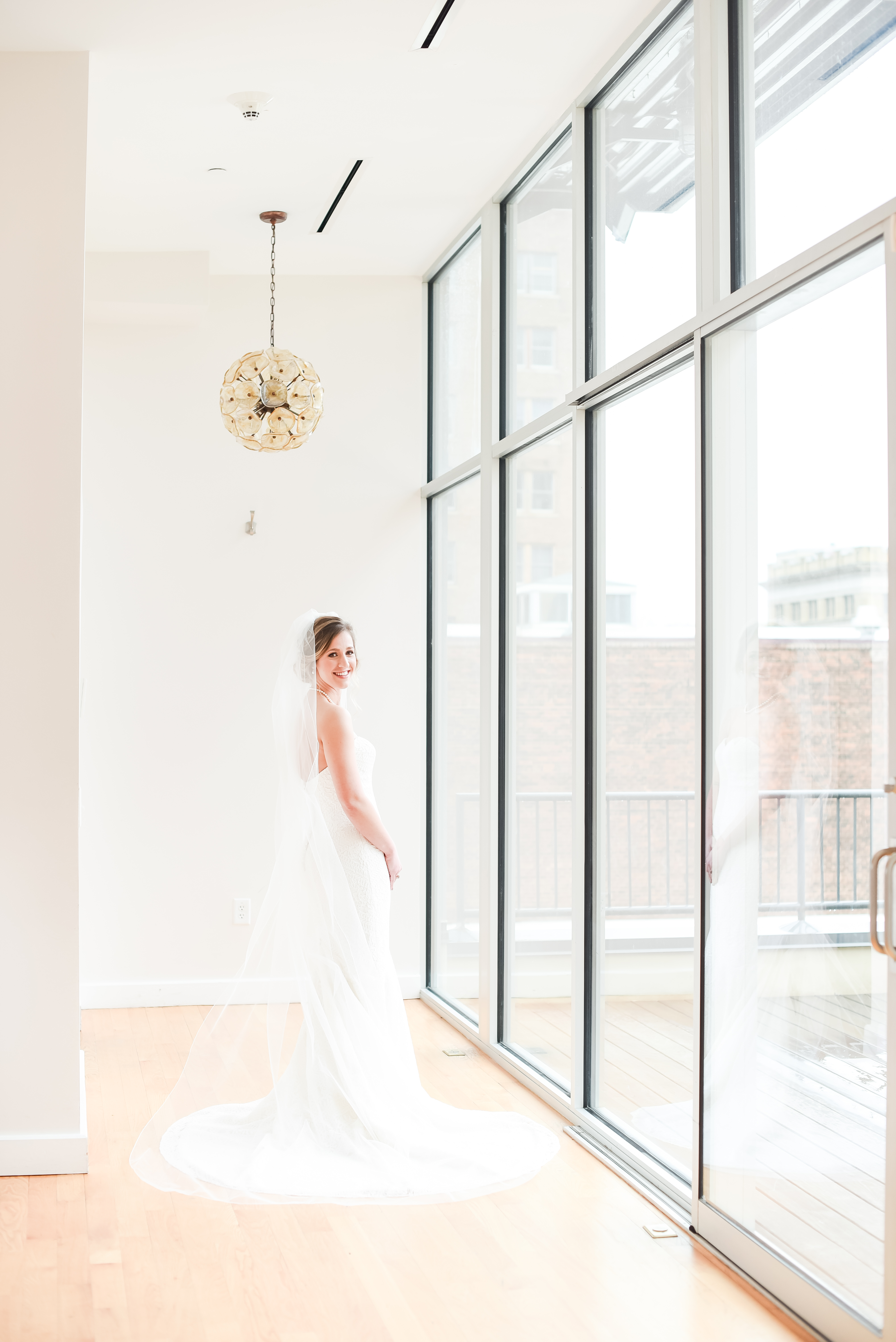 bride looking back with cathedral length dress at the Glass Box
