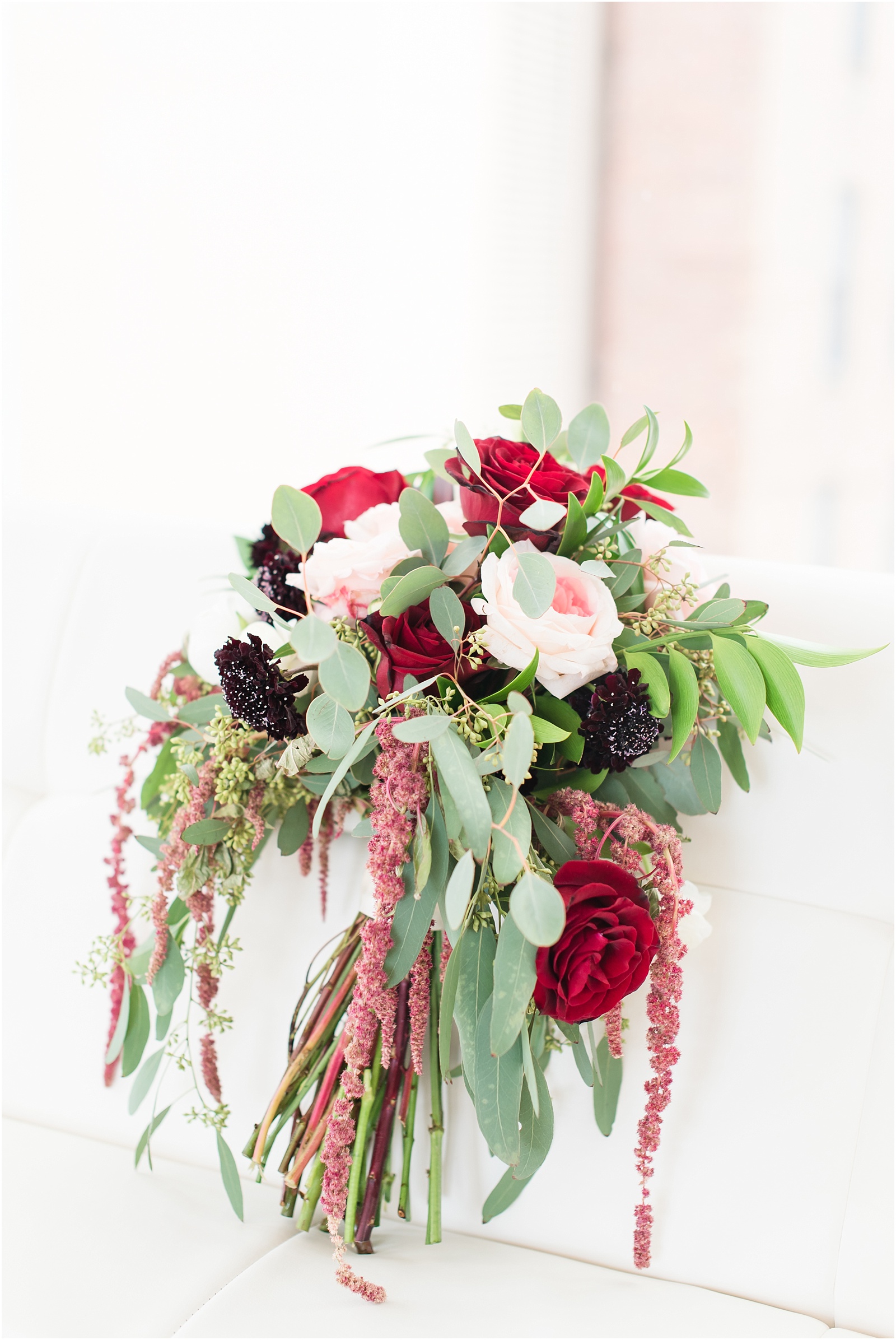 Gorgeous bridal bouquet with Pink and Red Roses, green sage leaves at the glass box