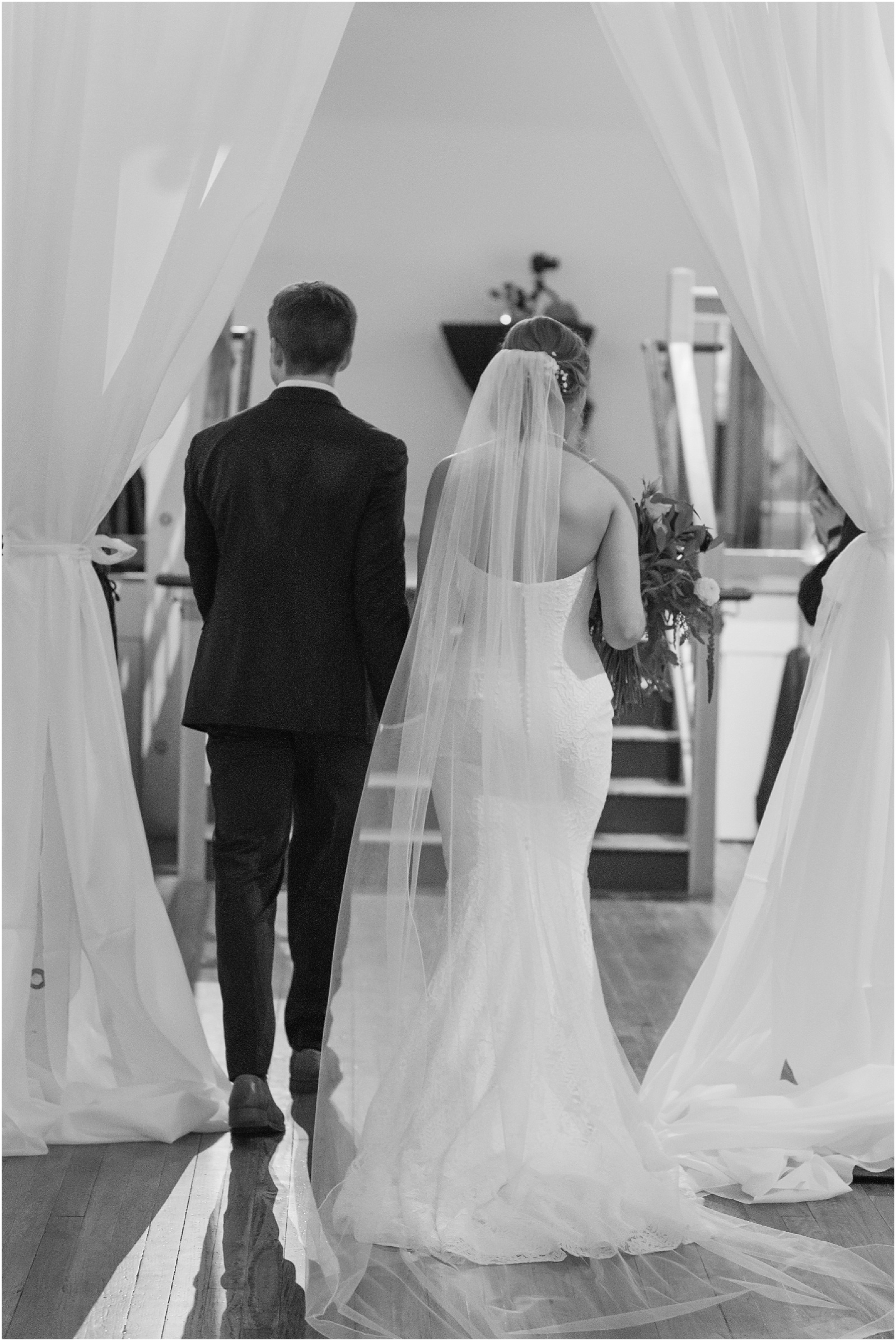 Bride and Groom walking hand and hand down the aisle at the Stockroom at 230