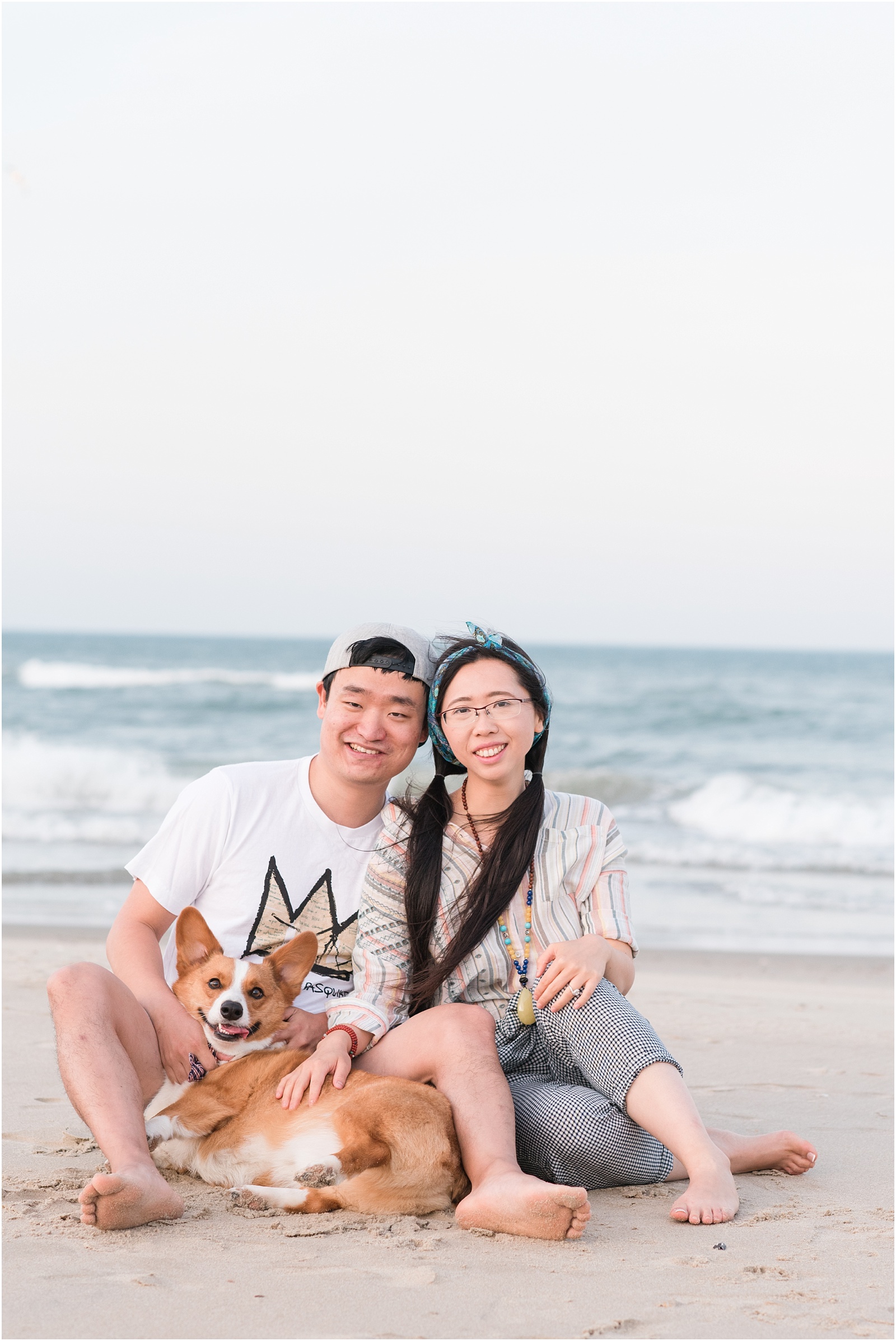 engaged couple with corgi on corolla beach