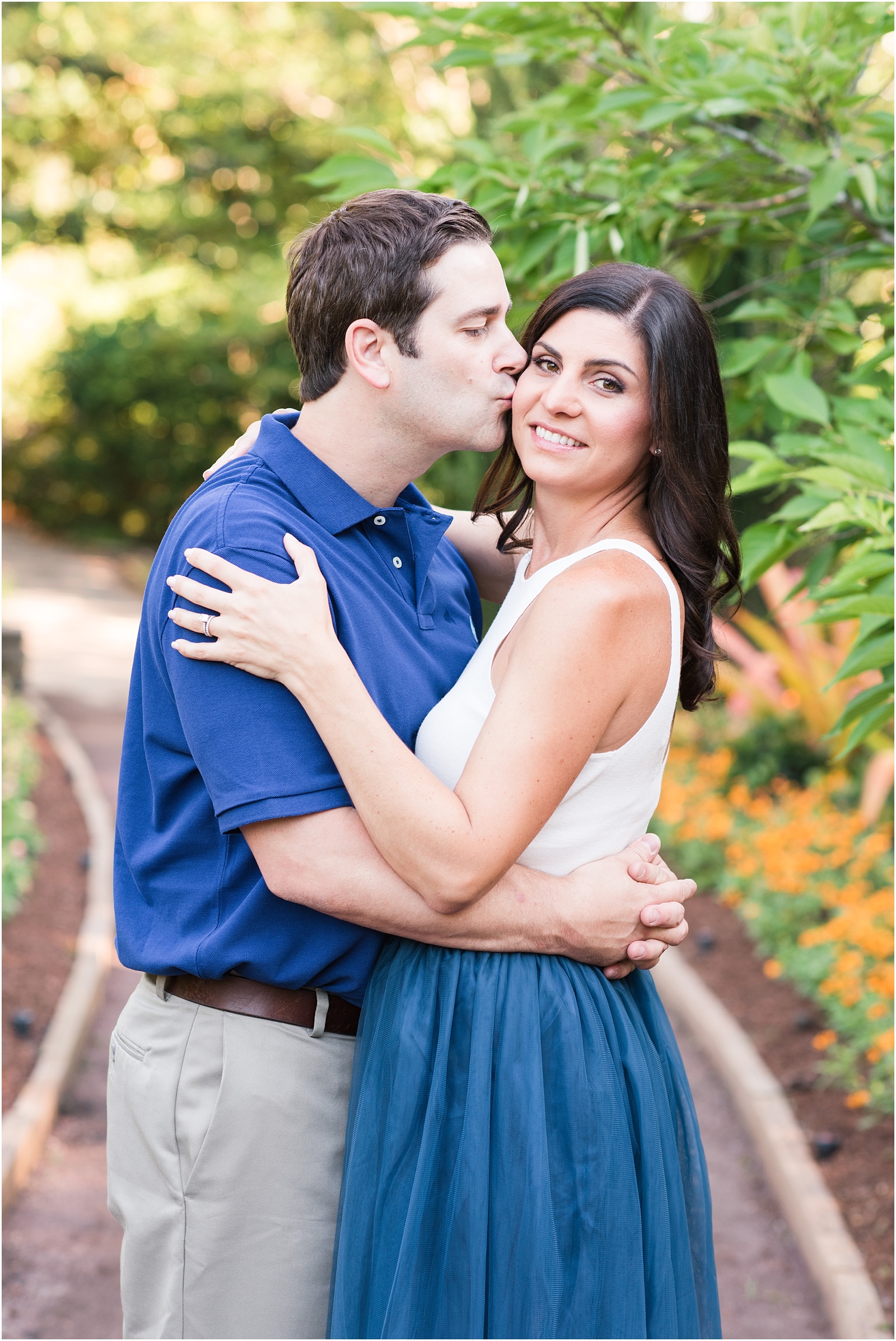 a husband kissing his wife on the cheek at Duke Gardens