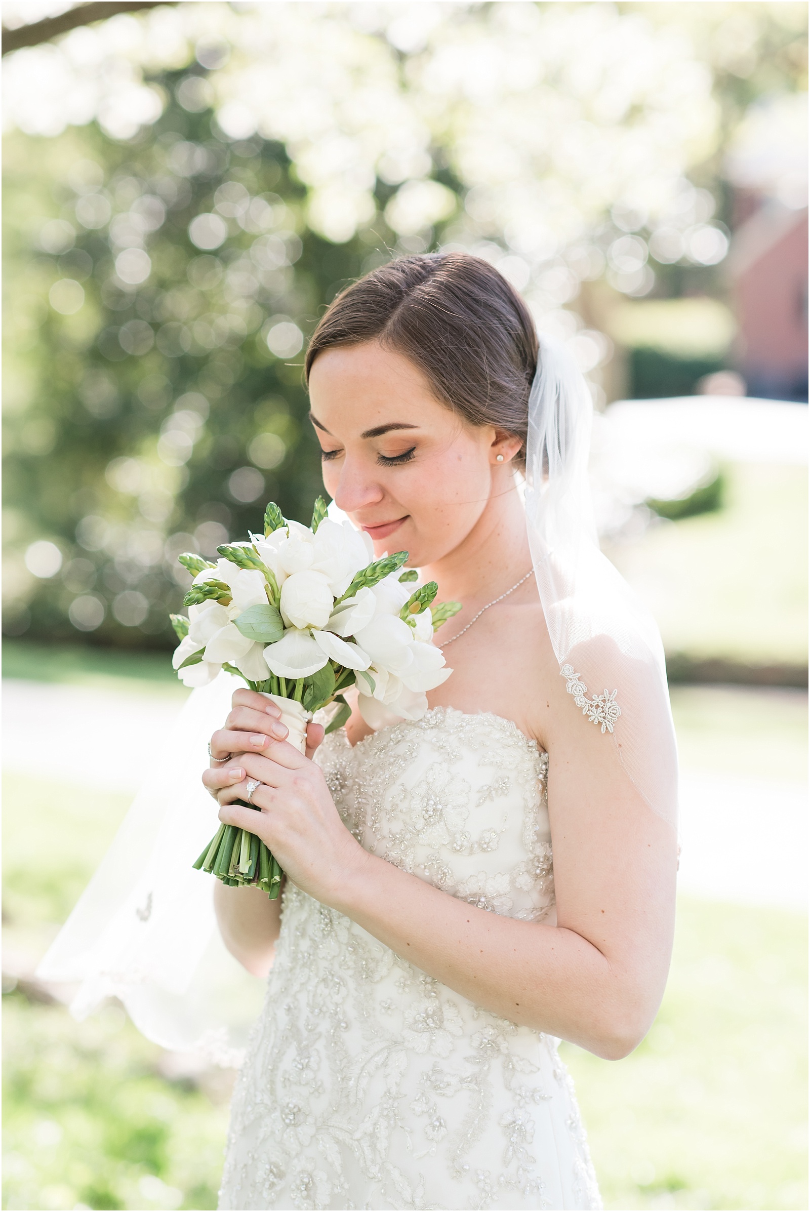 bride sniffing white and green bridal bouquet outside at a Home Estate bridal session