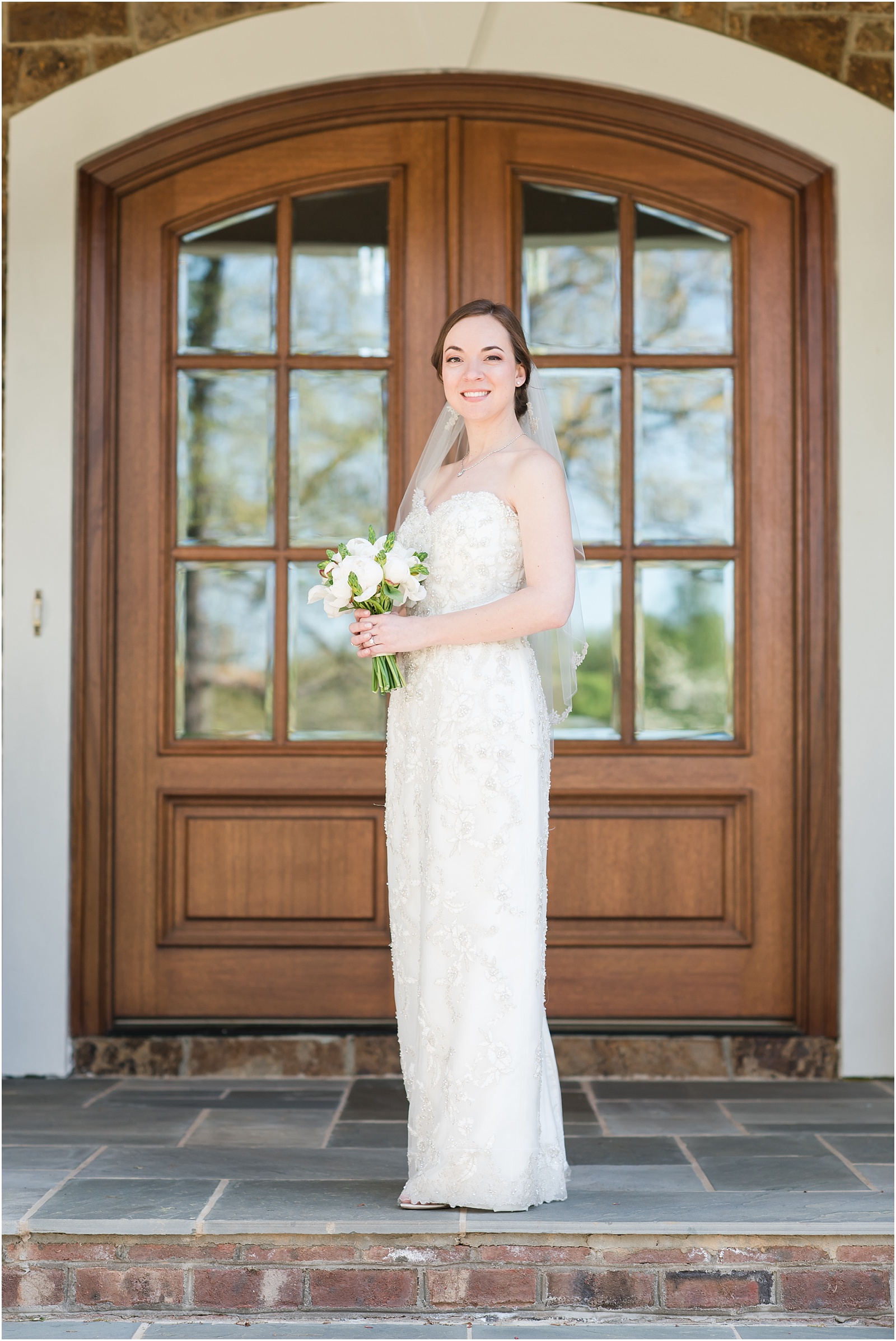 bride standing on front porch holding wedding bouquet at a Home Estate