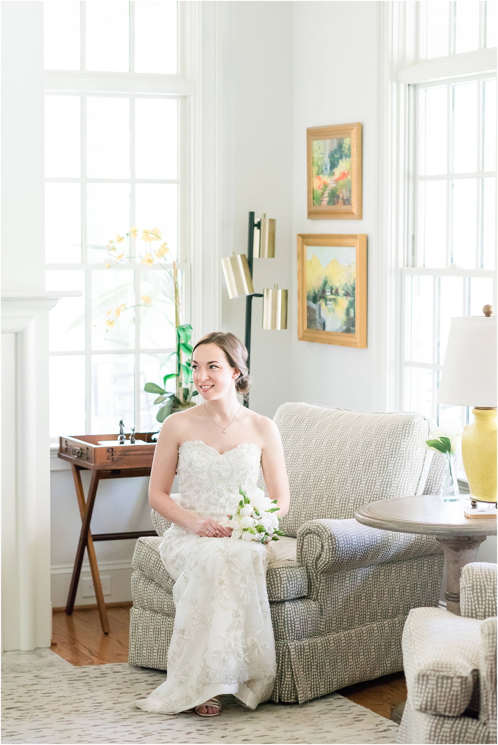 bride sitting on couch inside home estate holding white and green wedding bouquet at a Home Estate