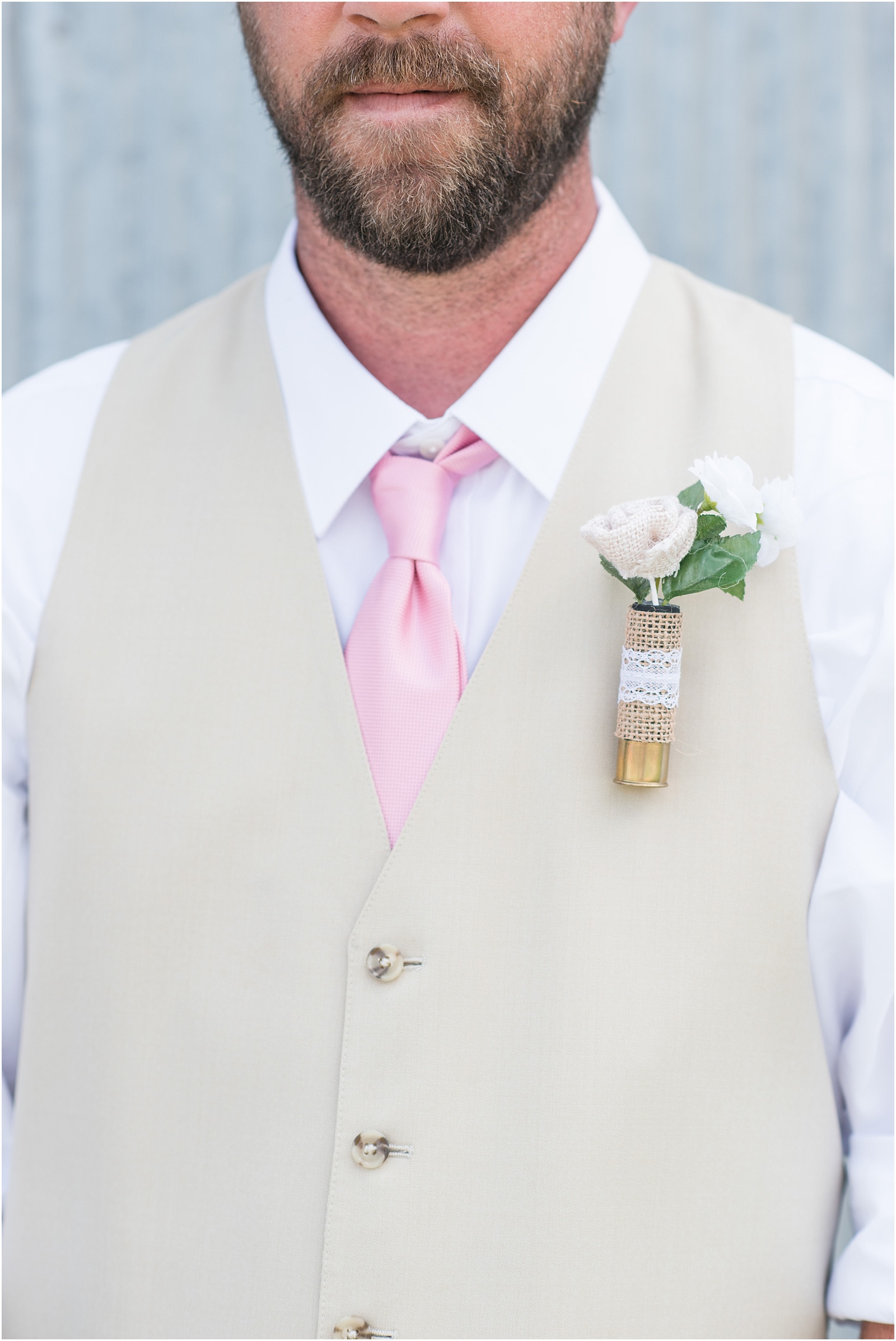 groom details that have a pink tie with a tan vest at Starlight Meadow