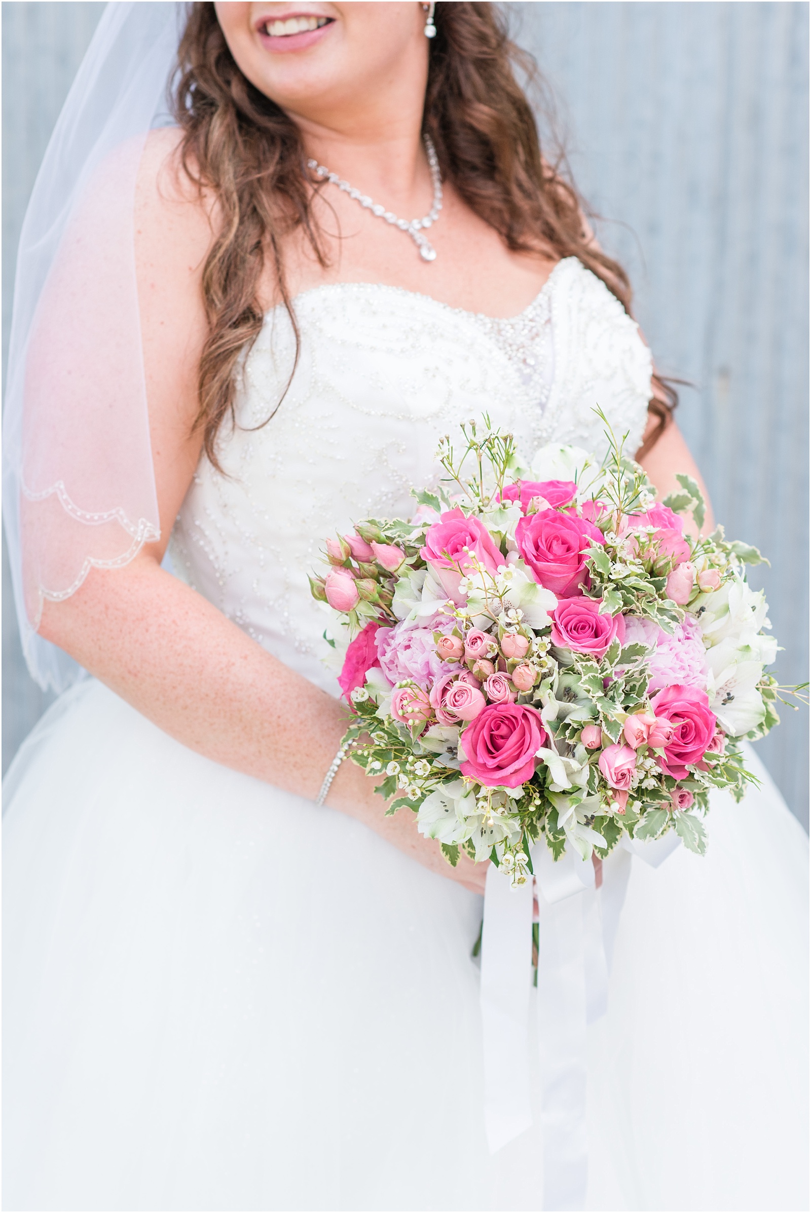 bride holding pink, peach, green, and ivory wedding bouquet at Starlight Meadow