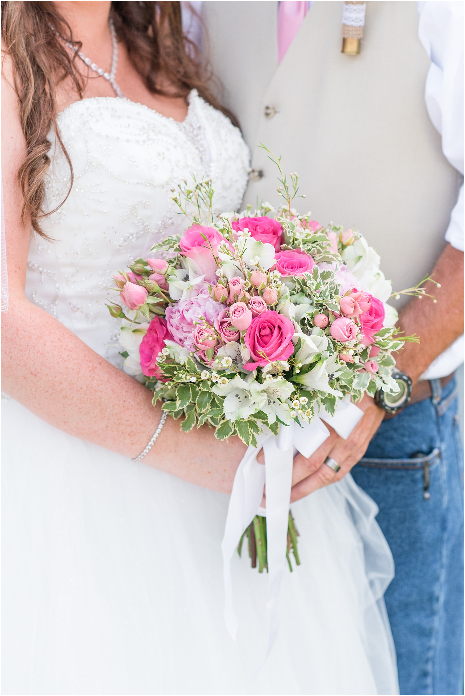 bride and groom holding a pink, peach, green, and white bridal bouquet with a tan vest and pink tie Starlight Meadow