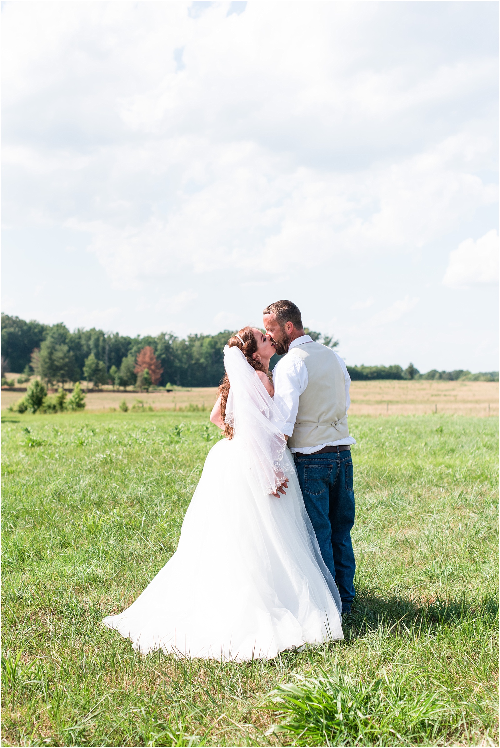 bride and groom walking in the field kissing each other at Starlight Meadow
