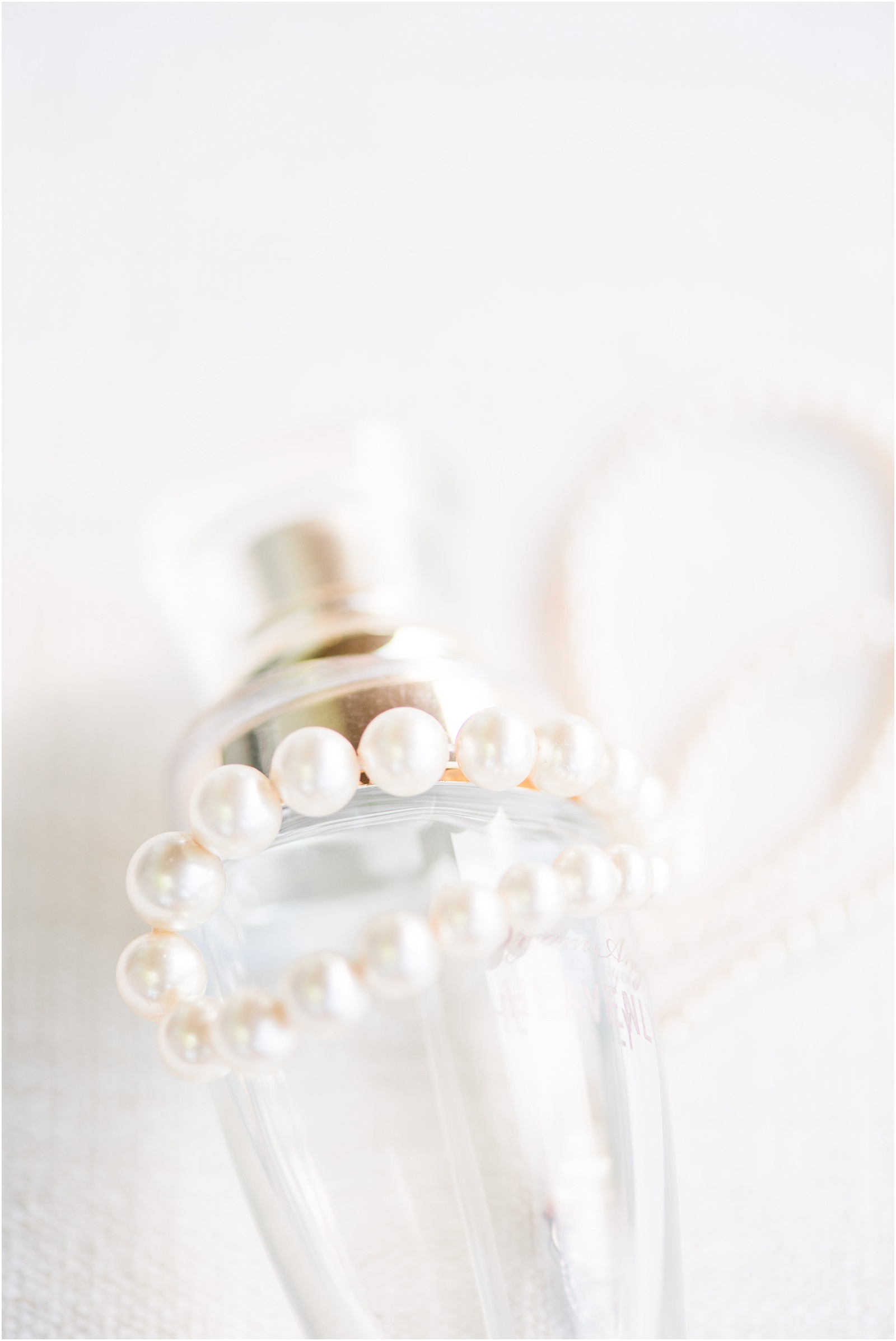 wedding pearls laying over perfume bottle at Starlight Meadow