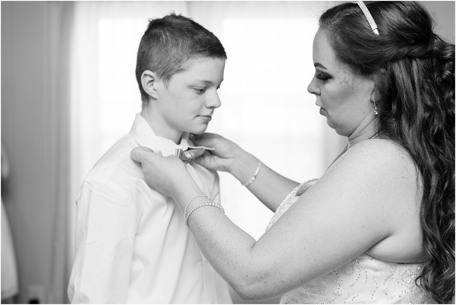 bride helping a young man getting bowtie on at Starlight Meadow