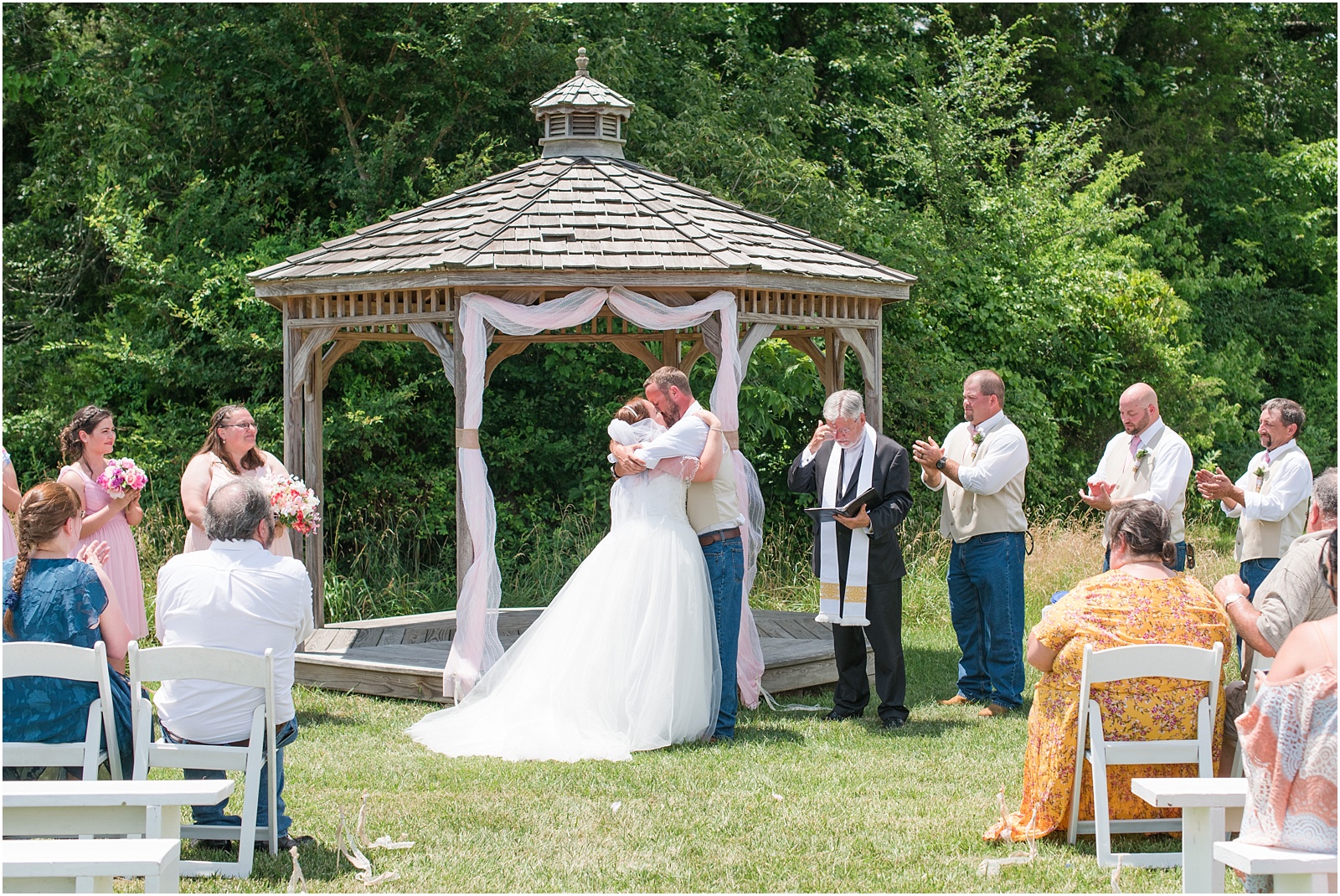 bride and groom kissing at ceremony at outdoor gazebo at Starlight Meadow