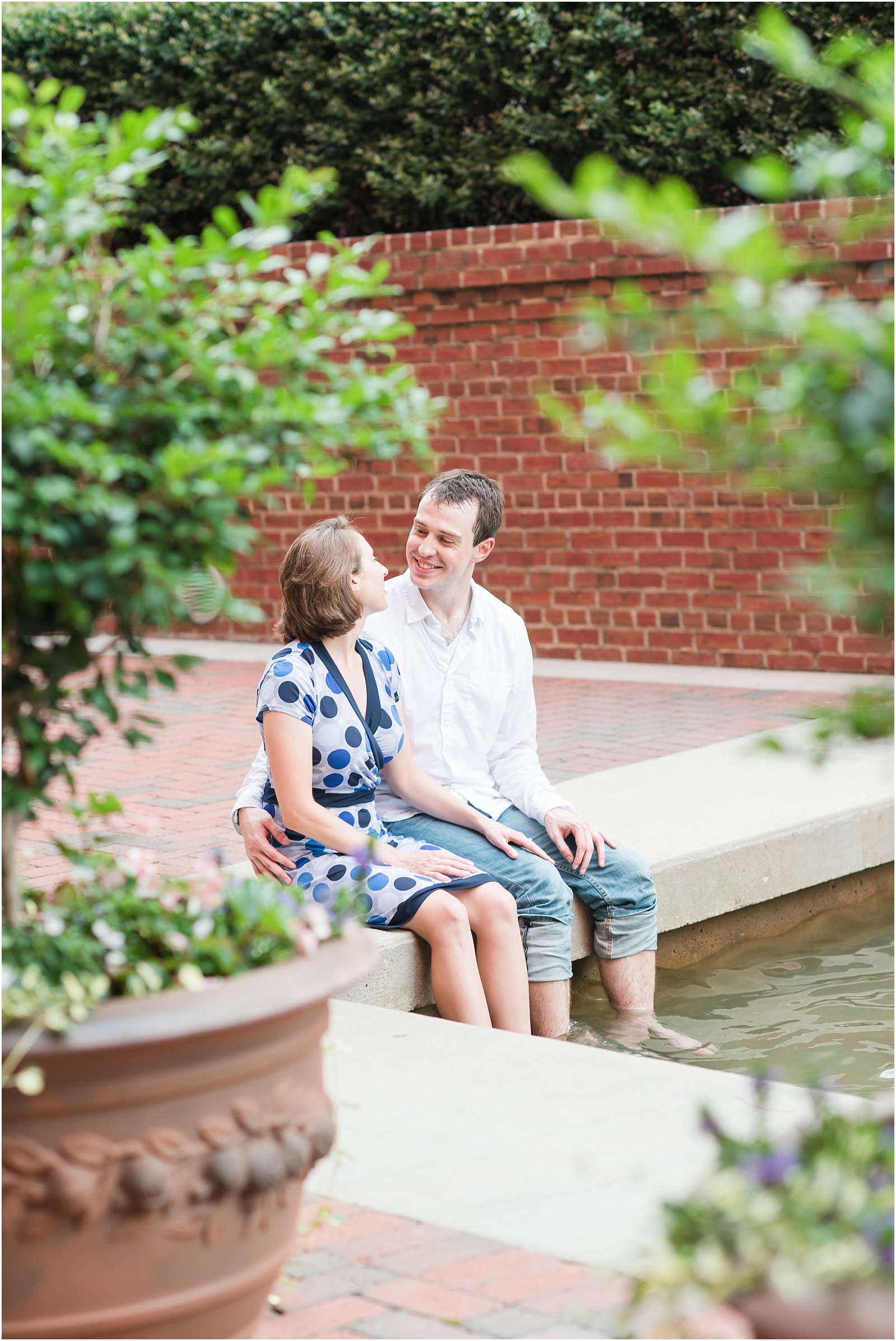 young couple sitting with feet in waterfall looking at each other at the American Tobacco Campus