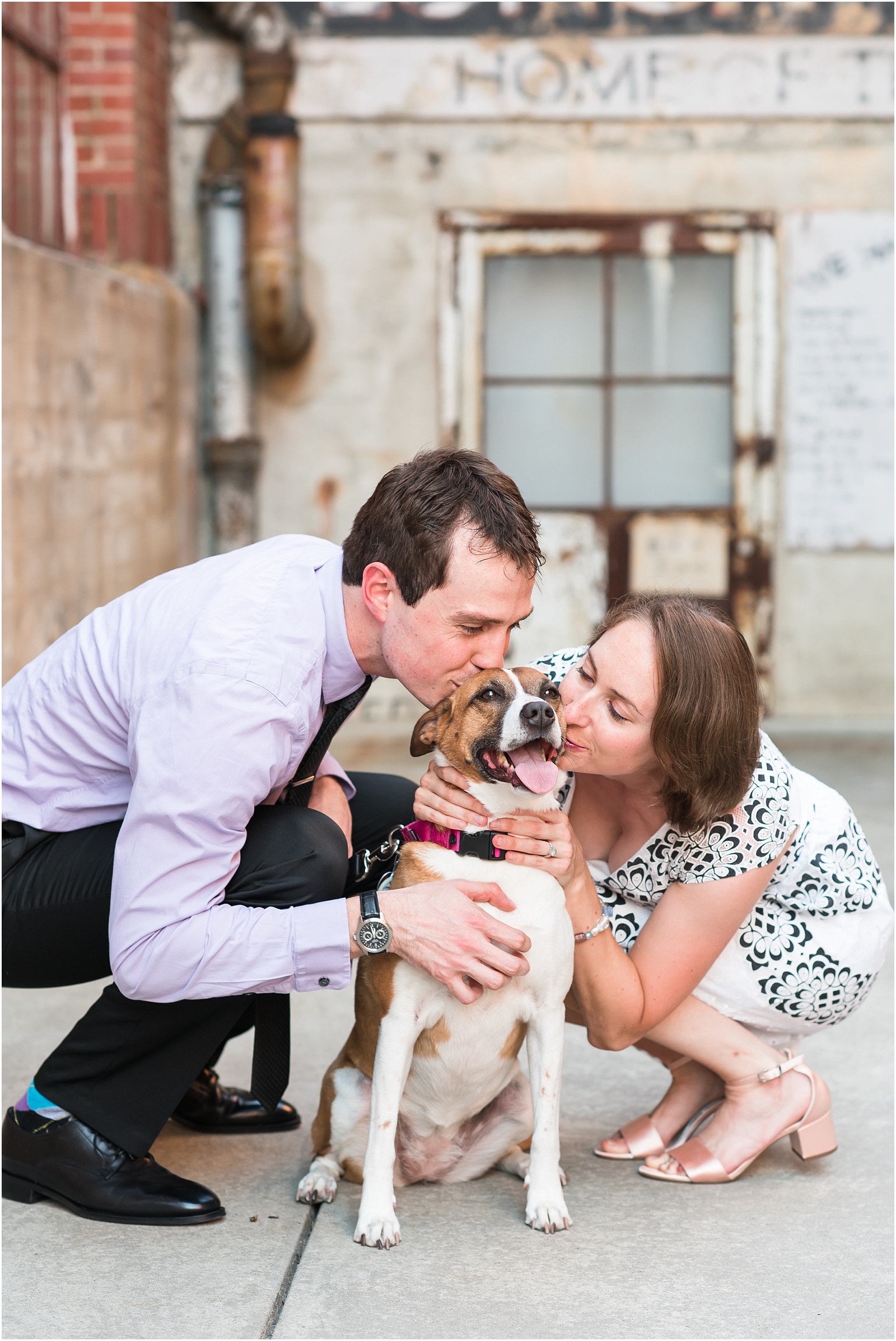 a bride and groom at their engagement session at the American Tobacco Campus kissing their sweet pup