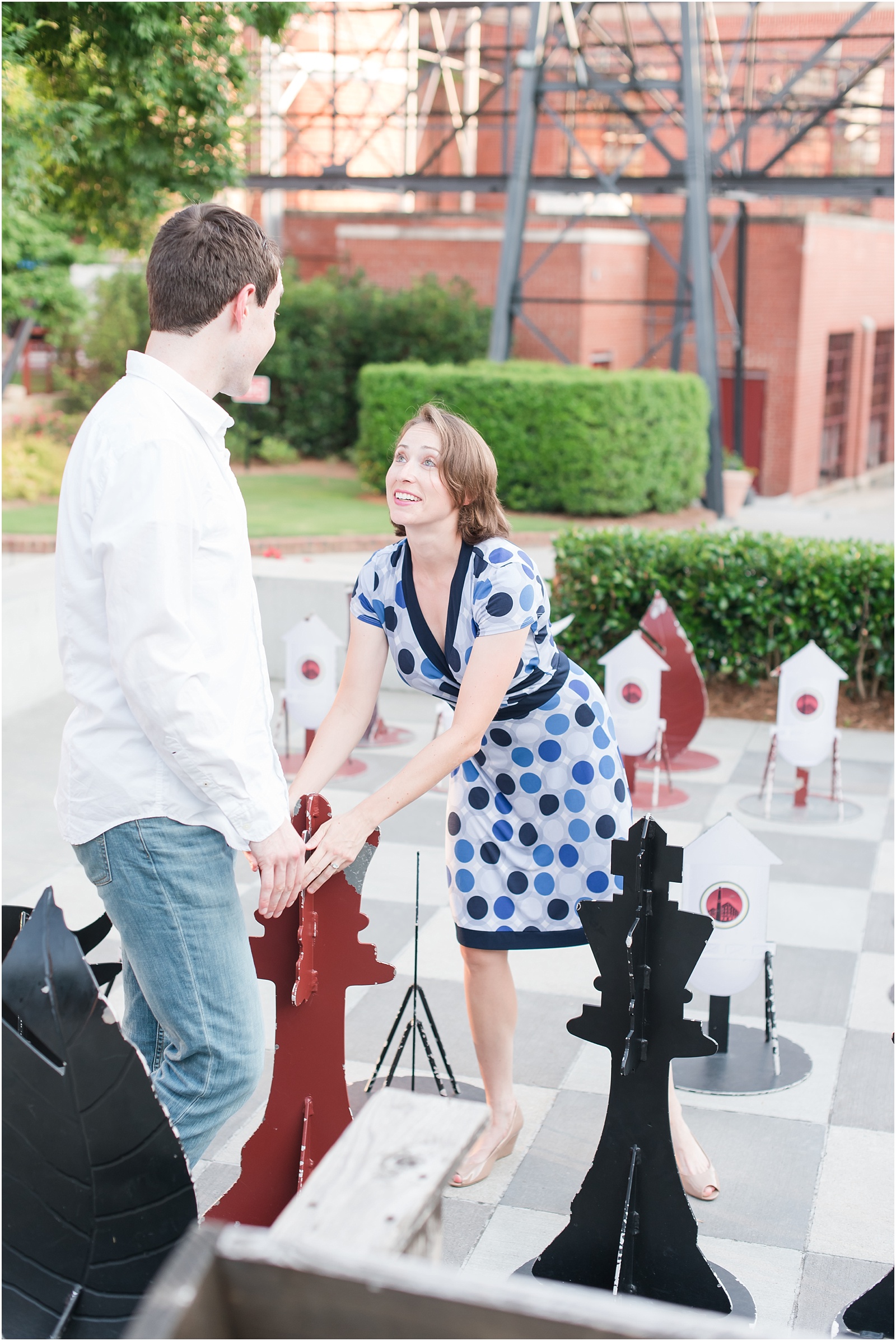 young couple playing with giant chess piece at the American Tobacco Campus