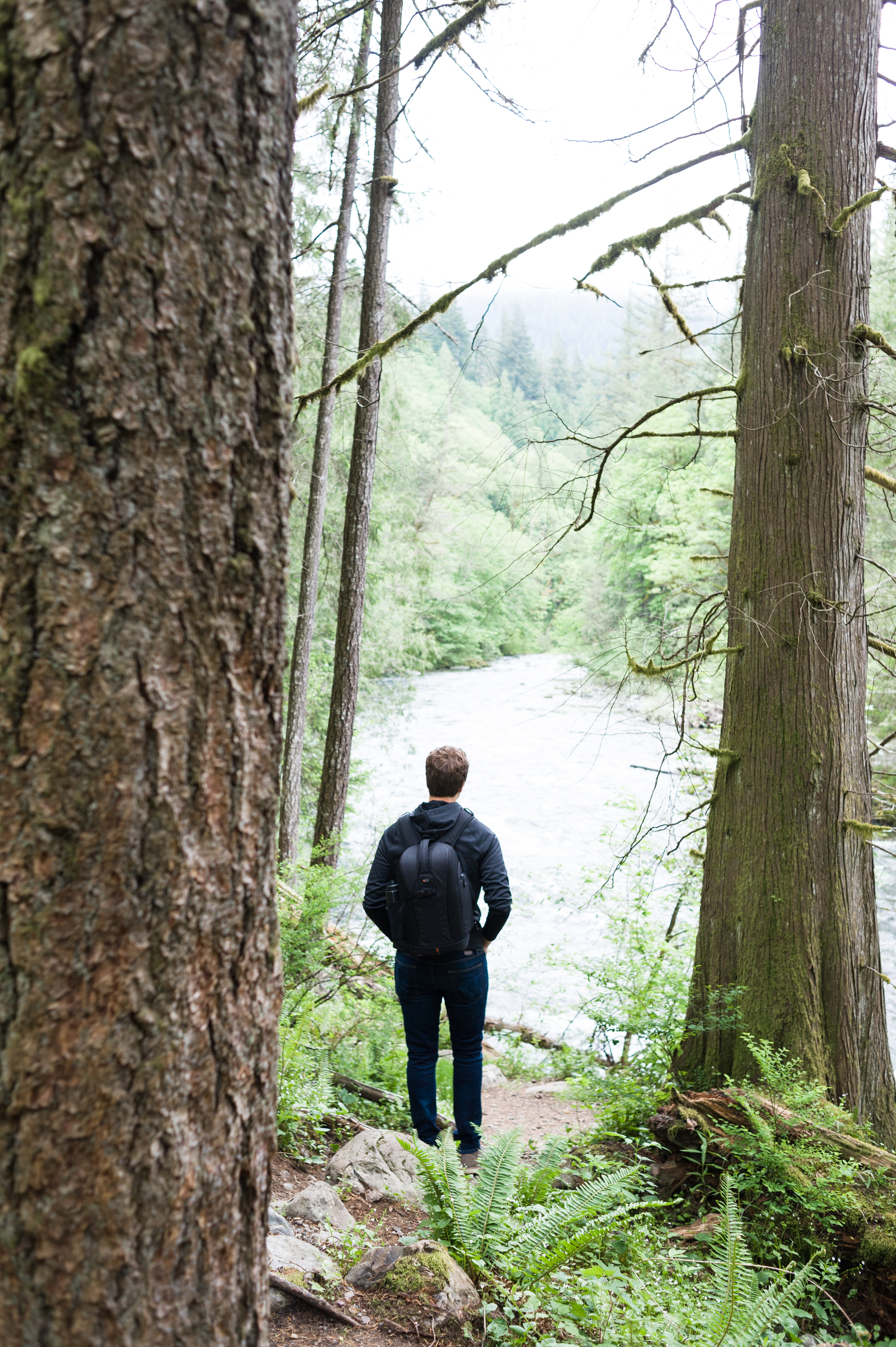 a photograph of a man looking out on a river at Twin Falls State Park Washington