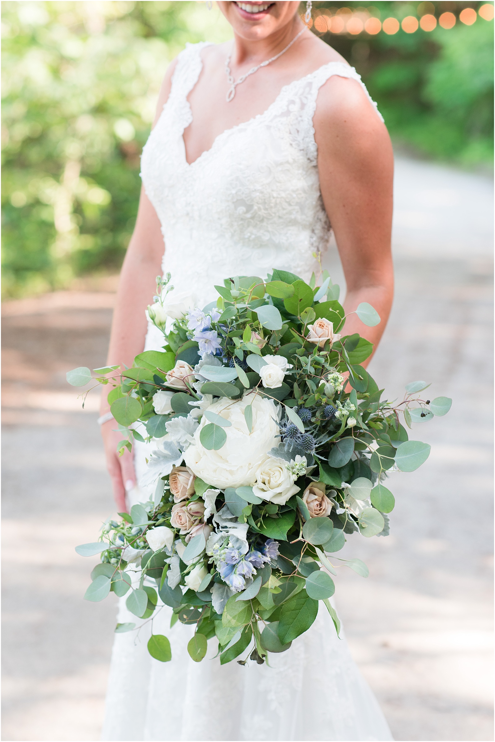 bride looking down at bridal bouquet at The Meadows At Walnut Cove