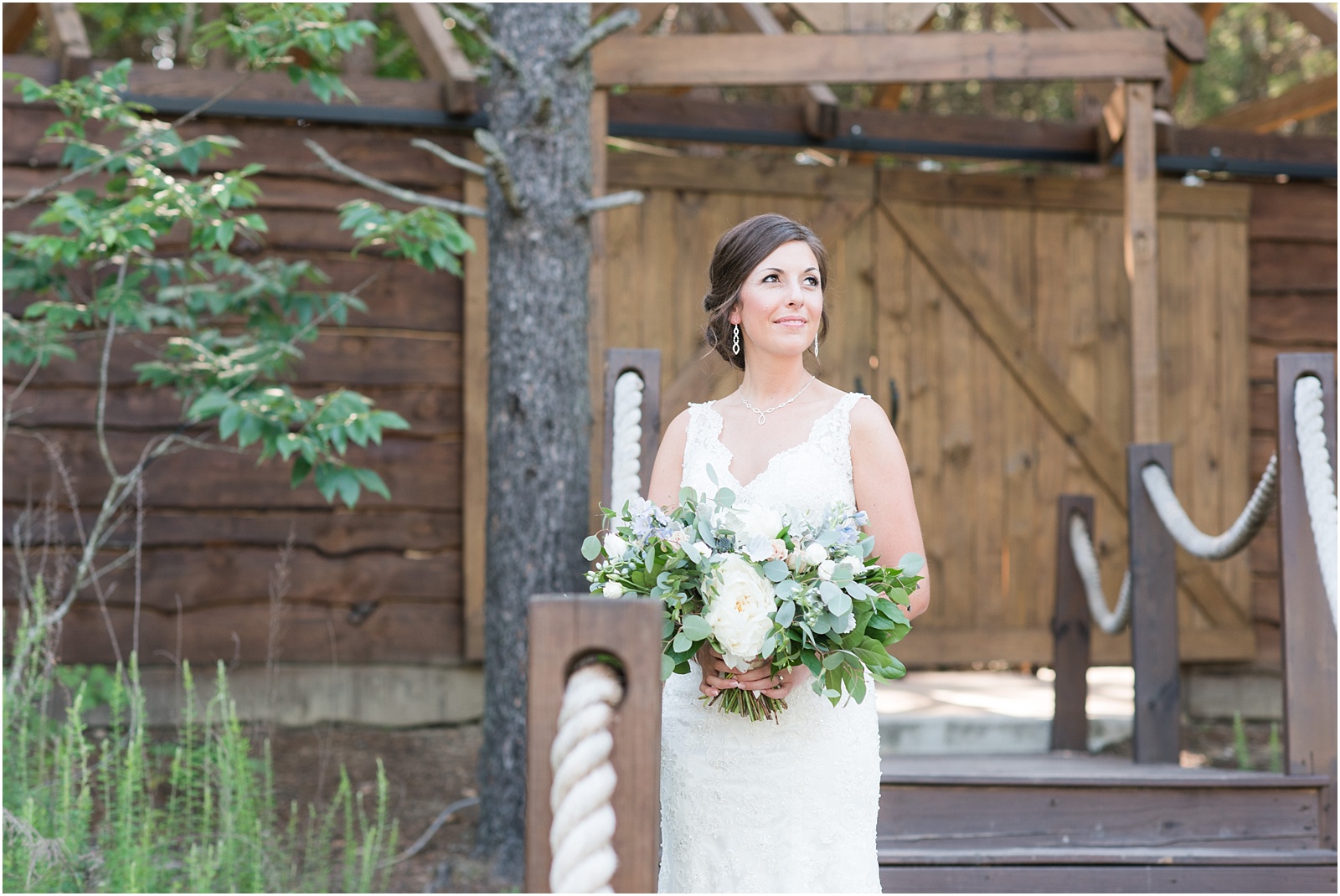bride looking up on stairs holding lush bridal bouquet at The Meadows At Walnut Cove