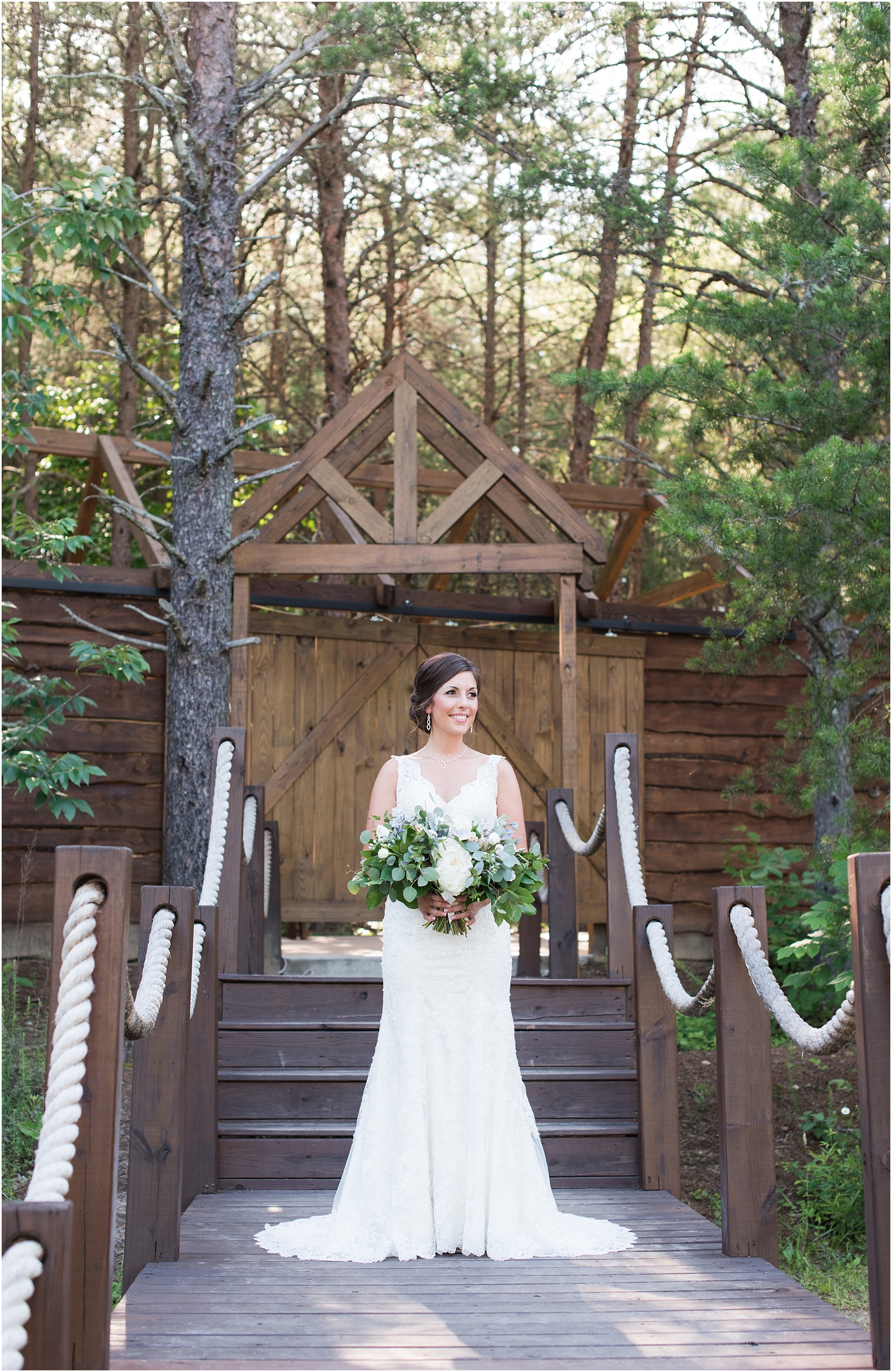 bride standing on stairs looking off into the distance holding bridal bouquet at The Meadows At Walnut Cove