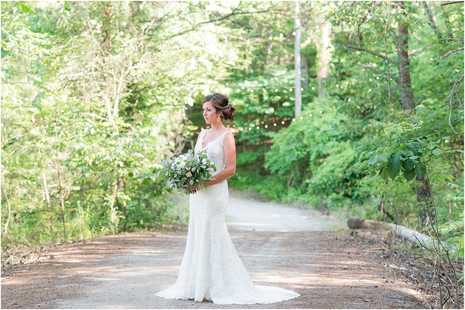 bride looking off to the side on pathway holding lush bridal bouquet at The Meadows At Walnut Cove