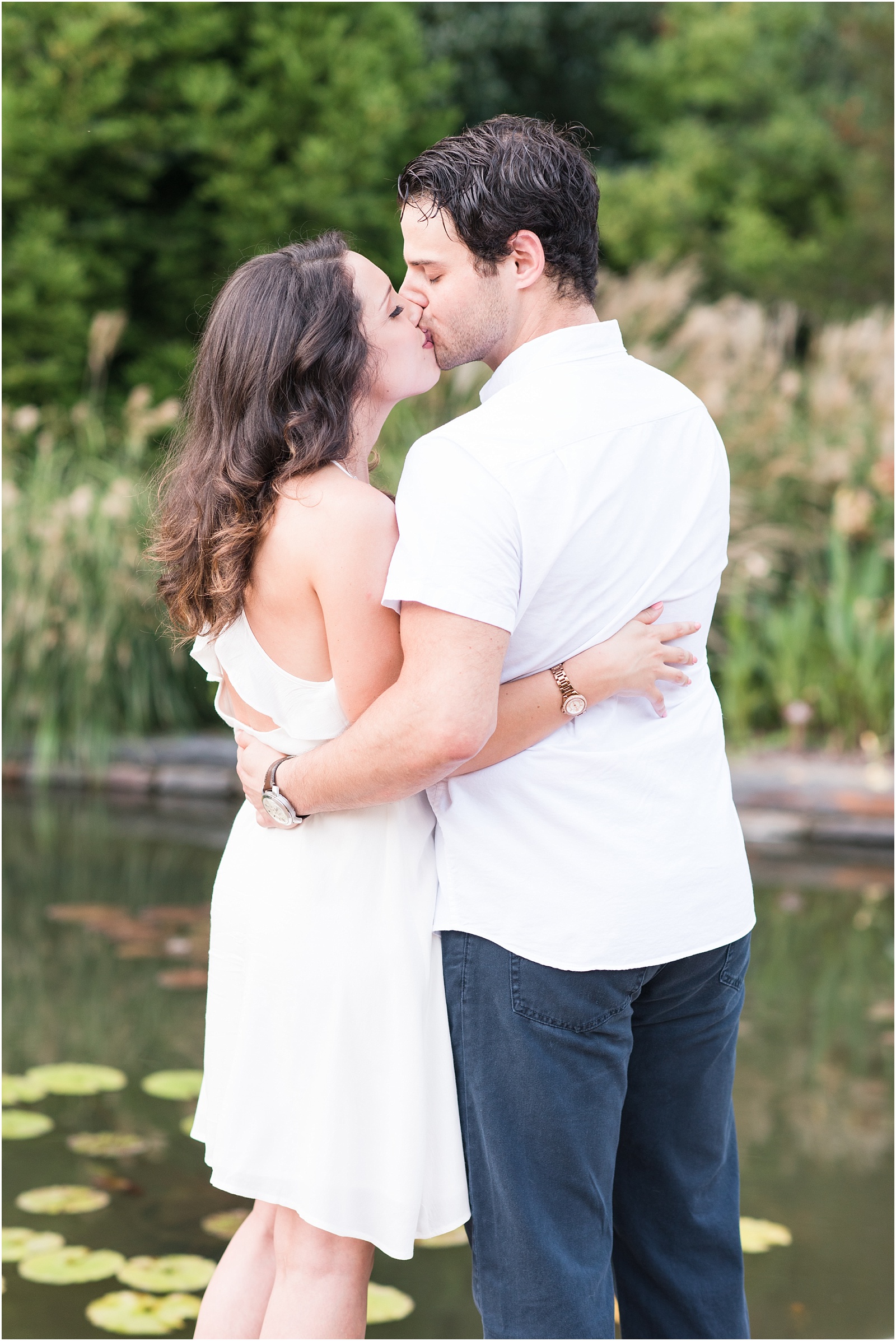 bride and groom kissing in front of a koi pond at Sarah P Duke Gardens