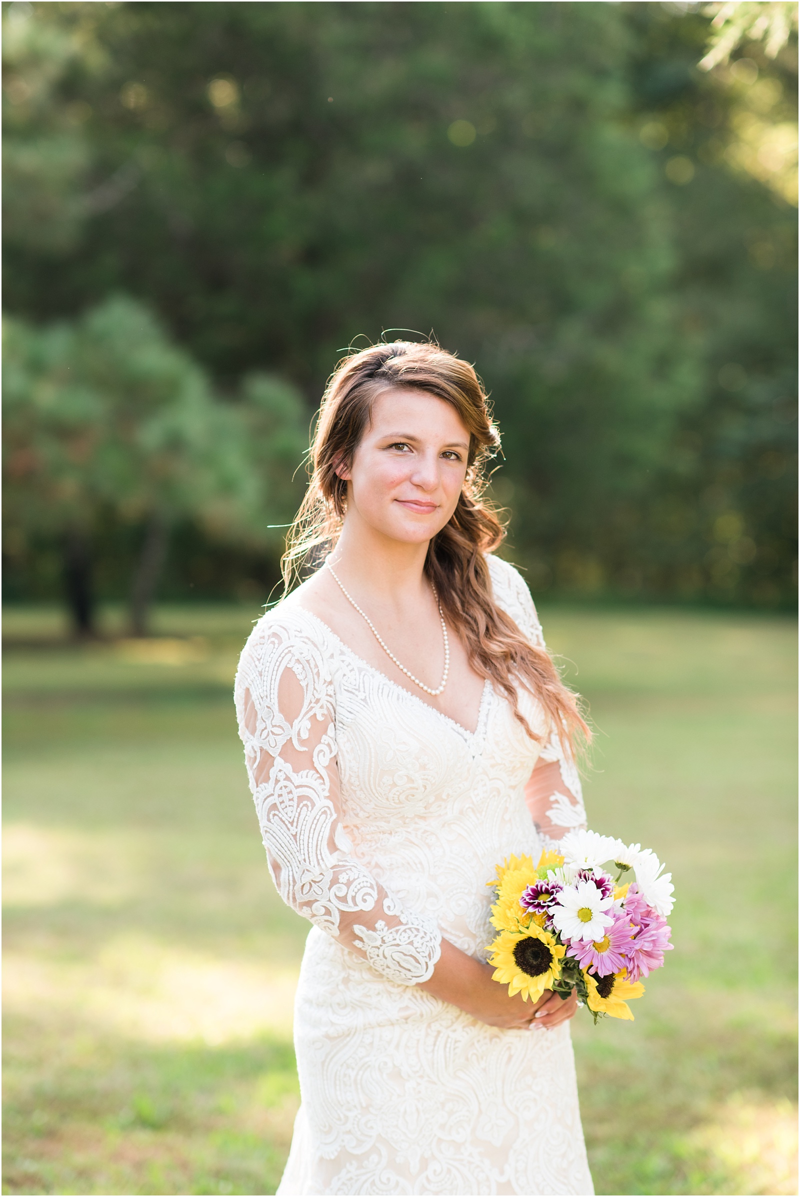 bride looking at camera holding sunflower bouquet wearing a chamange wedding dress