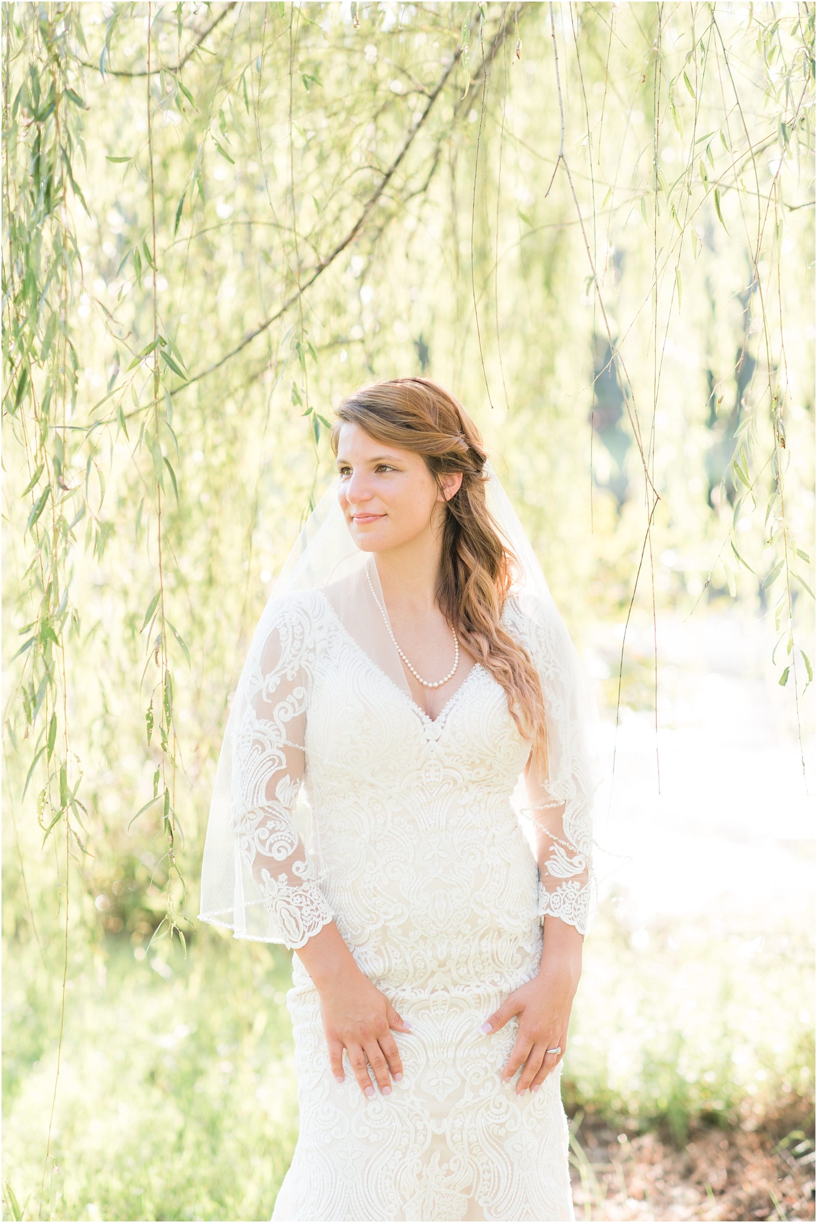 bride looking off at bridal session under a willow tree
