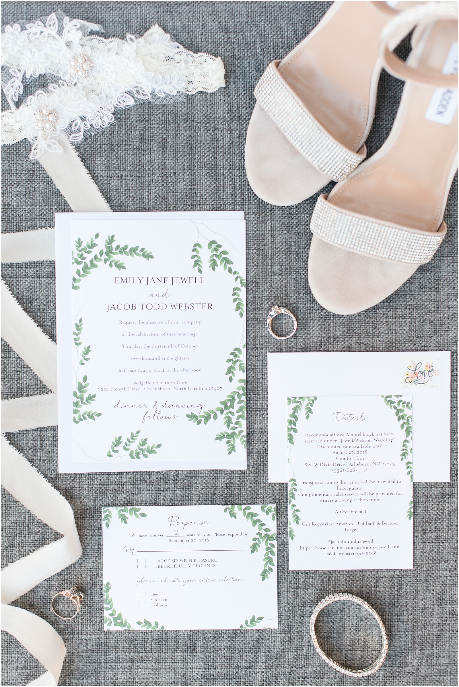 white and green wedding invitation suite on a gray background surrounded by two white laced garters, ivory ribbon, engagement ring, heirloom ring, sliver braclet, and cream colored heels